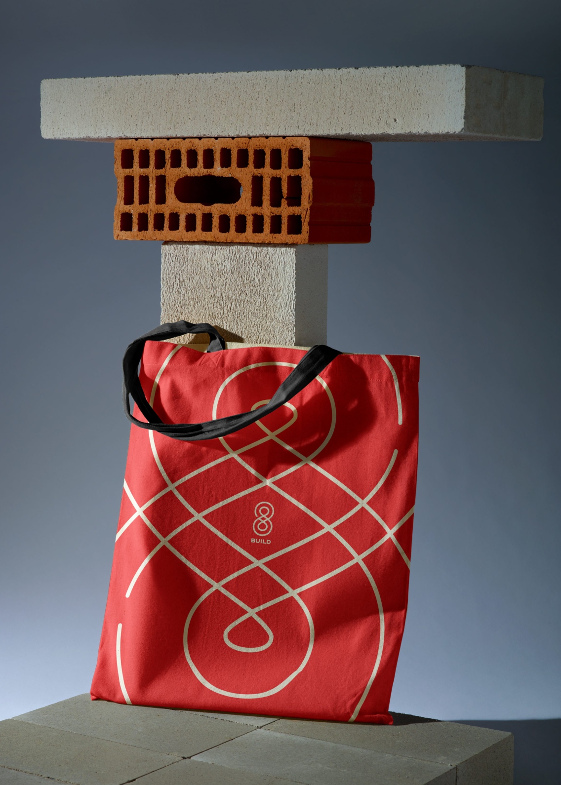 Red tote bag resting on breeze blocks