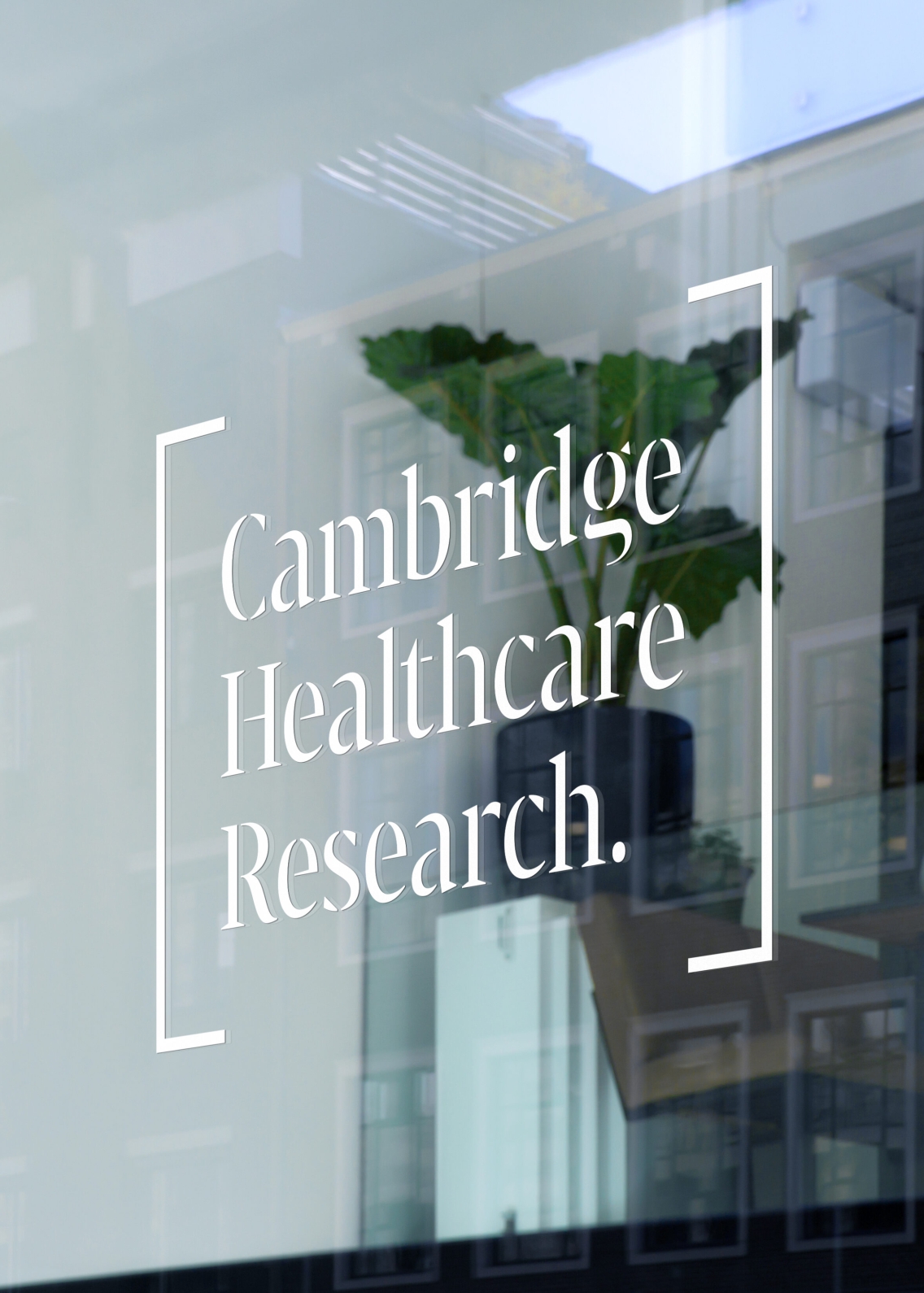 Cambridge Healthcare Research in square brackets (their logo) printed onto a glass window