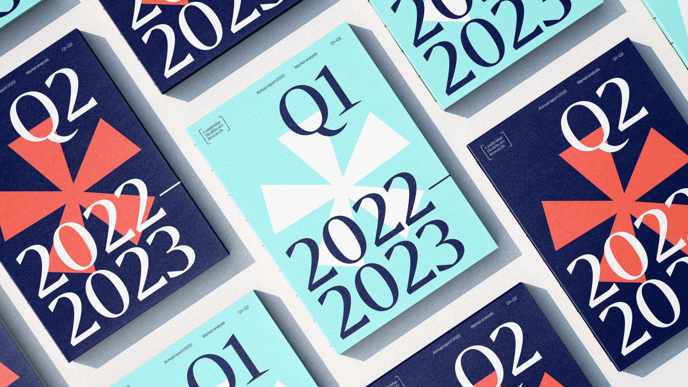 A selection of quarterly annual reports in various colours of pastel blue, deep orange and dark blue. Asterisks are featured in the centre fo each book