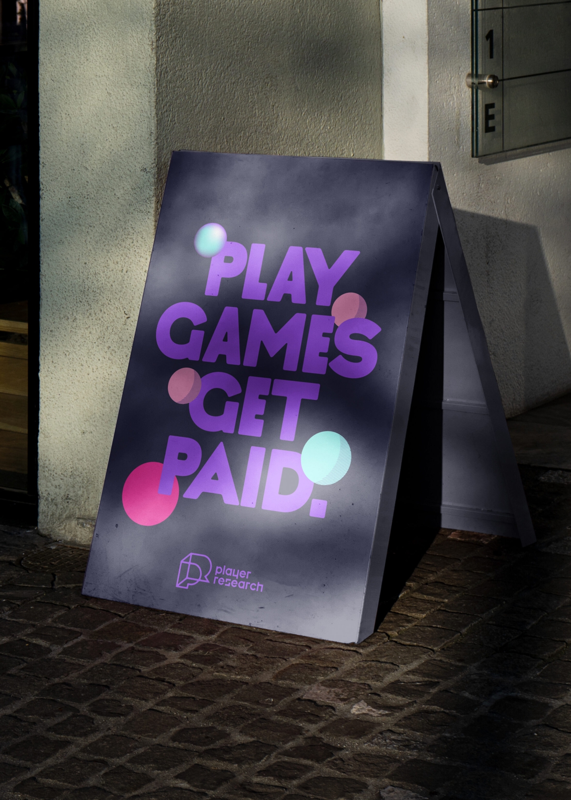 A board next to wall displays text - play games get paid.