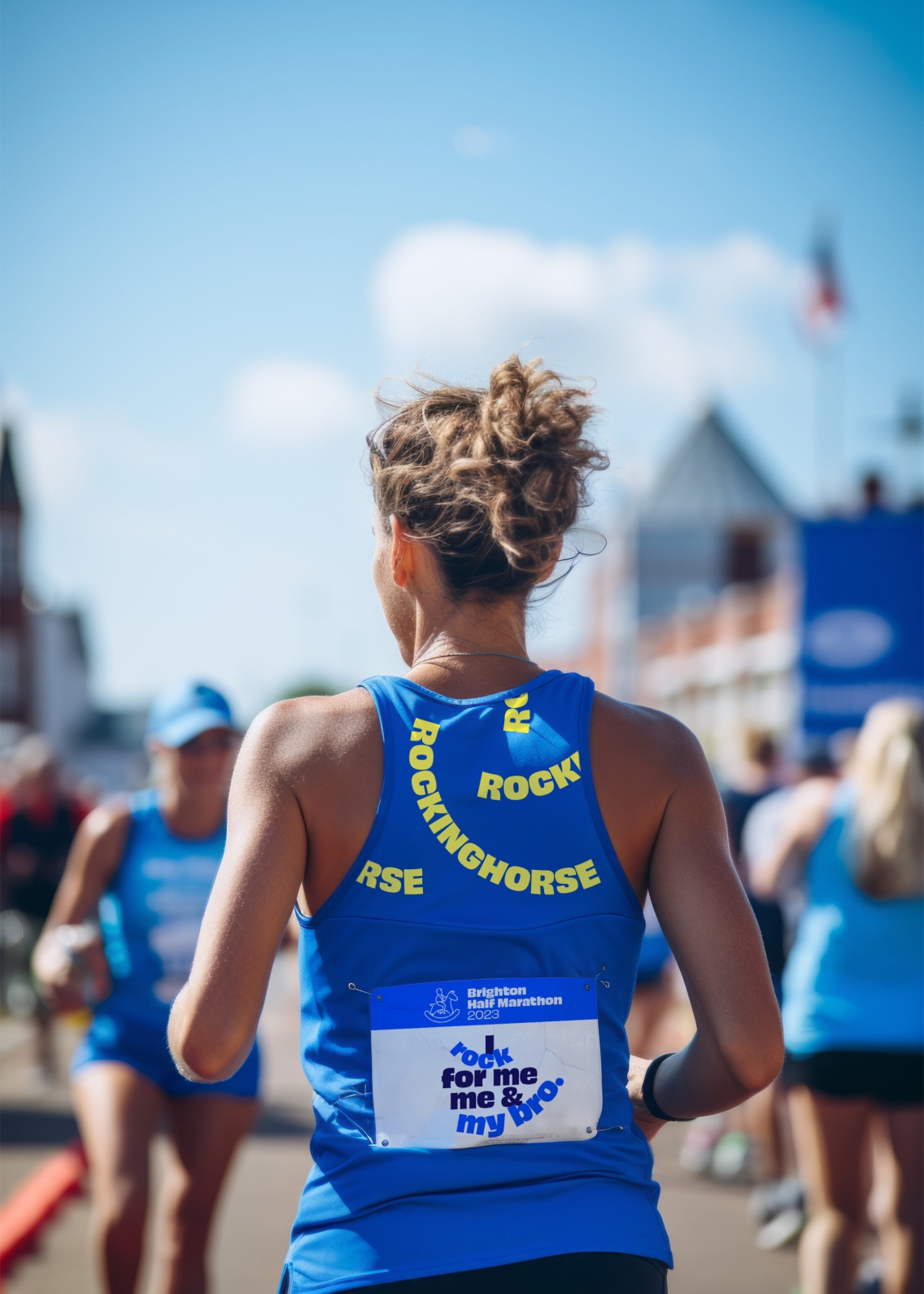 A woman running in a competition for fundraising for Rockinghorse wearing a blue Rockinghorse running vest